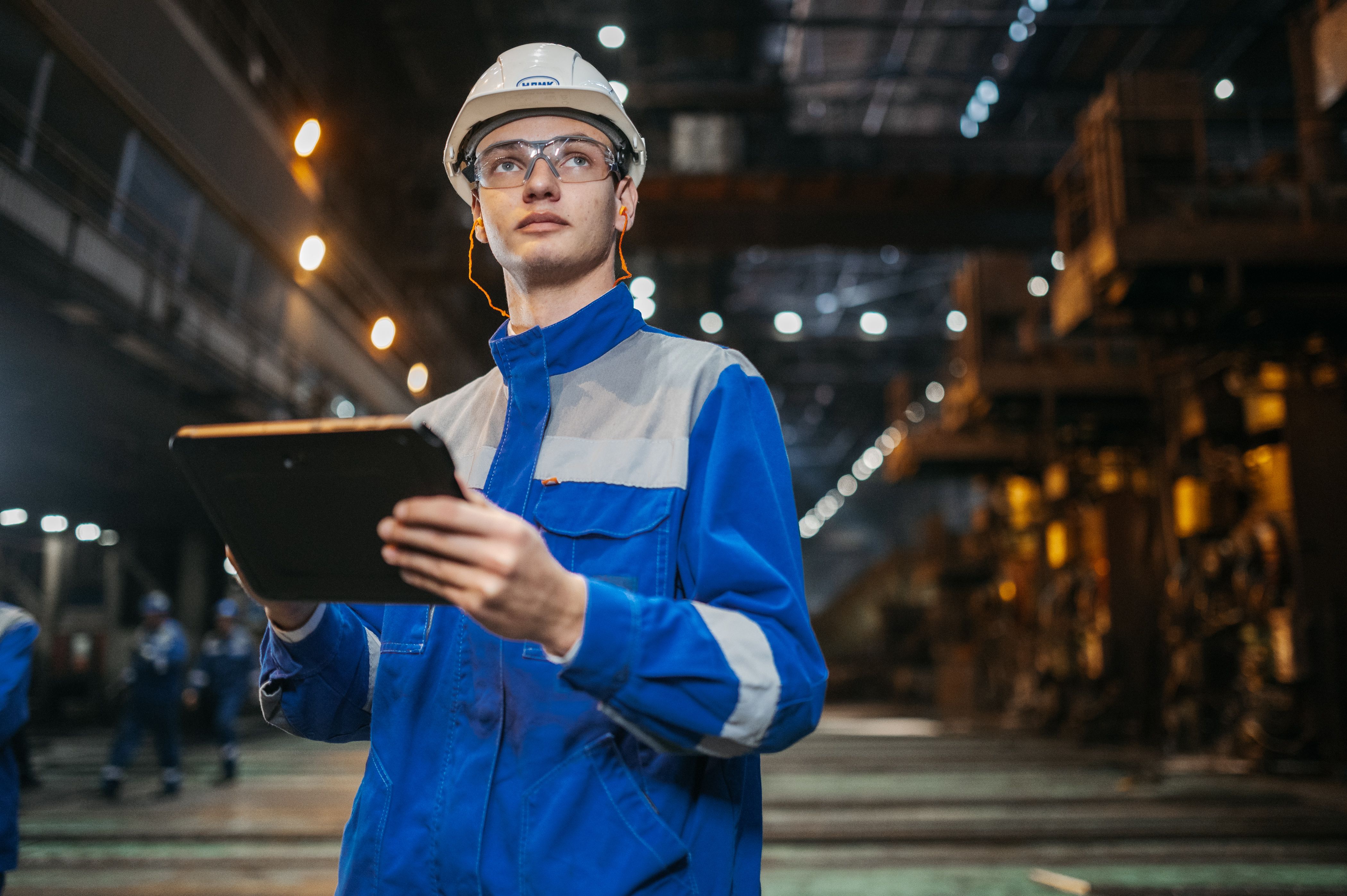 Ingeniero industrial con equipo de protección supervisando una planta